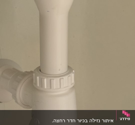 צינור פלסטיק לבן עם מחבר מתחת לכיור